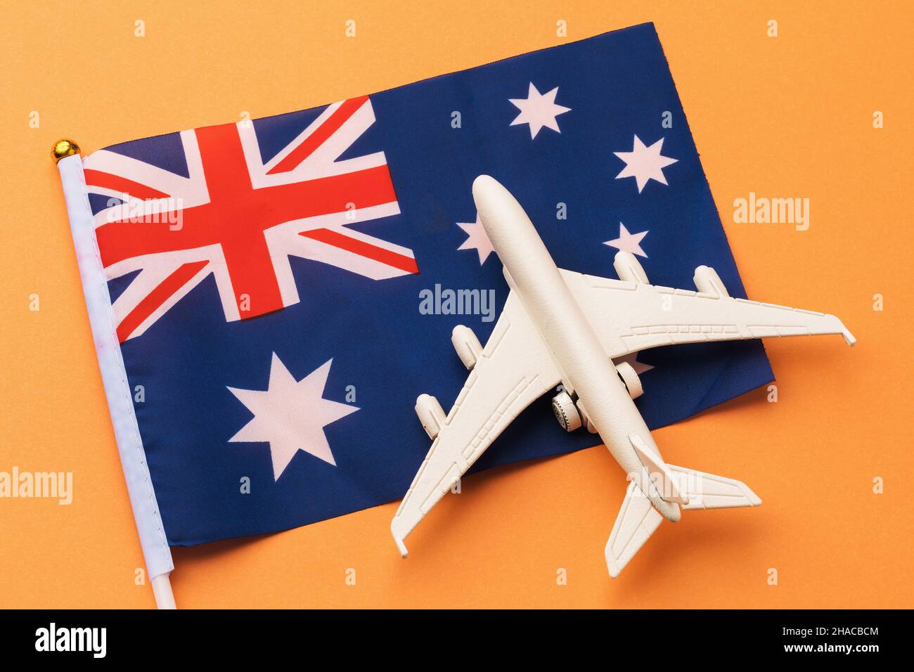 Drapeau australien et avion jouet sur fond coloré, un concept sur le thème du voyage en Australie Banque D'Images