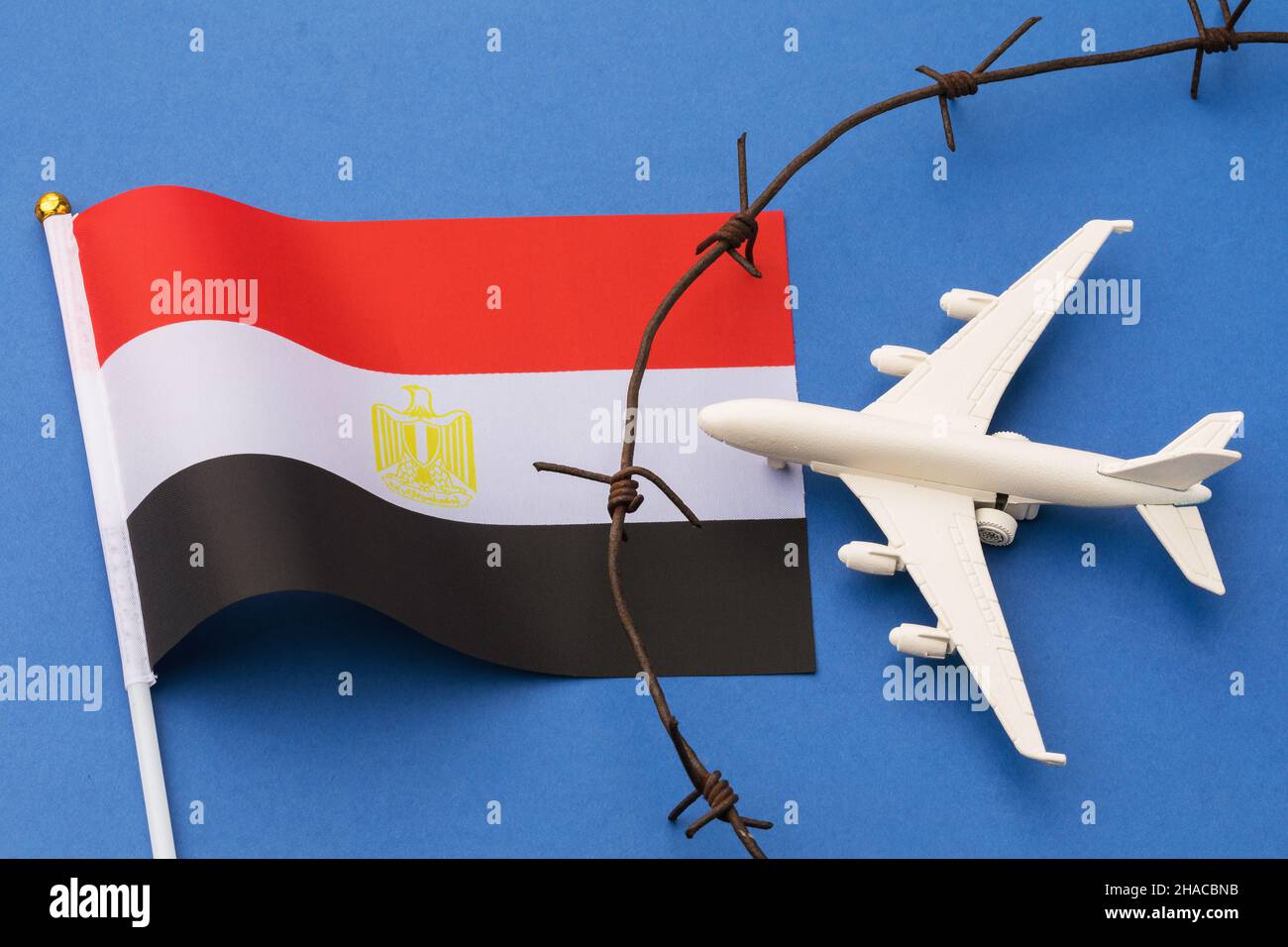 Avion jouet, drapeau égyptien et barbelé sur fond de couleur, Égypte concept de violation de la frontière aérienne Banque D'Images