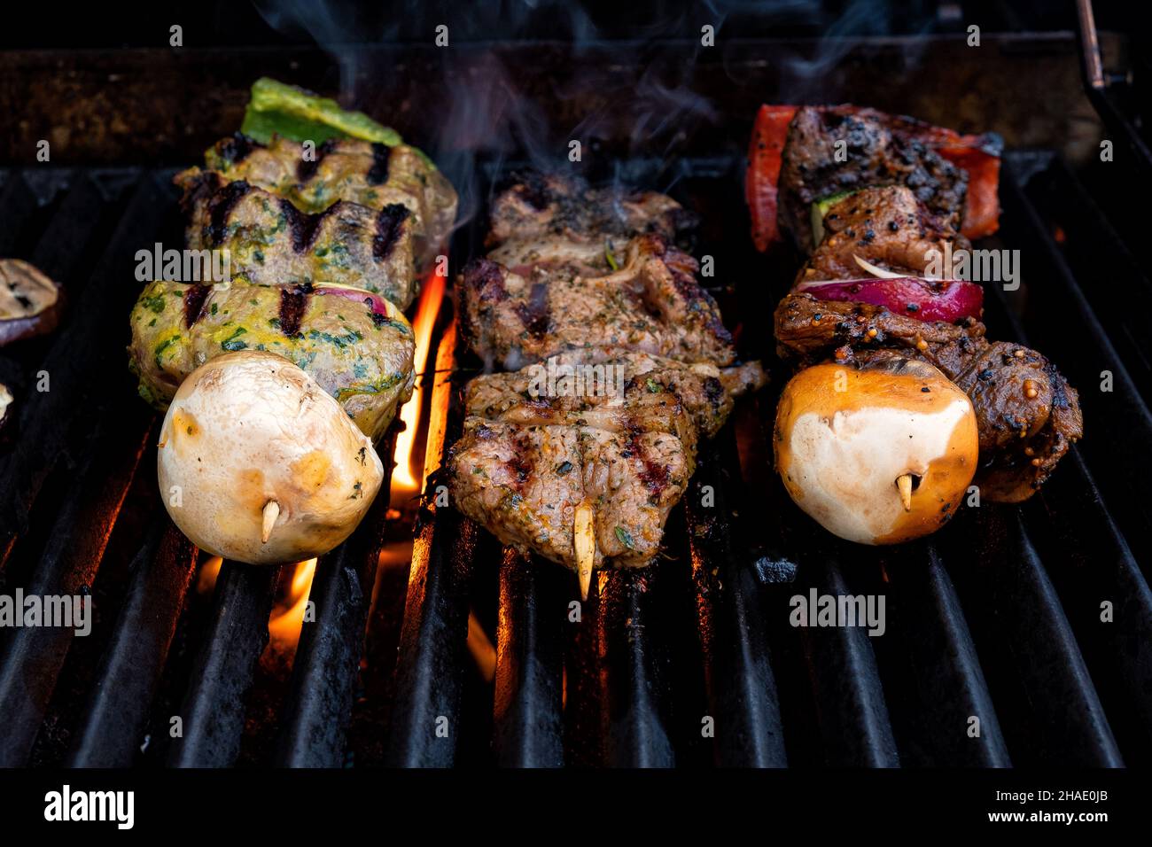 dîner grillé en été sur un barbecue avec des flammes en dessous Banque D'Images
