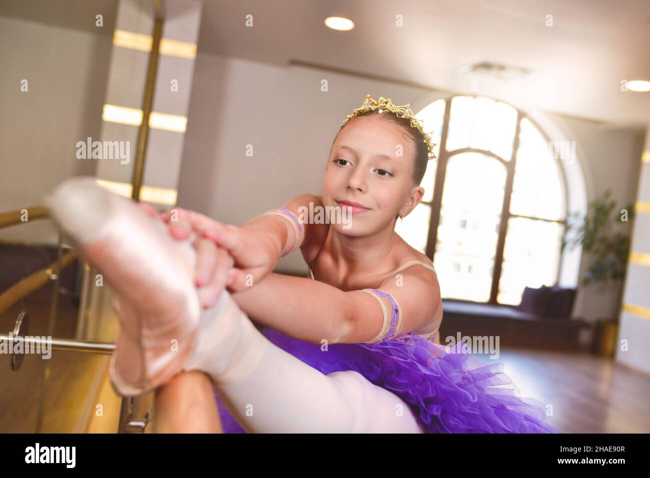 adolescente portant des chaussures pointe en classe de ballet, près d'un cadre et grand miroir elle fait des exercices et étirements Banque D'Images