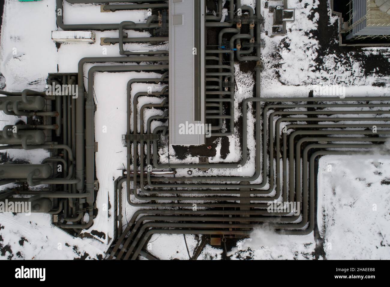 Des pipelines complexes dans une centrale géothermique ont tiré avec un drone pillé, en hiver avec de la neige sur le sol Banque D'Images