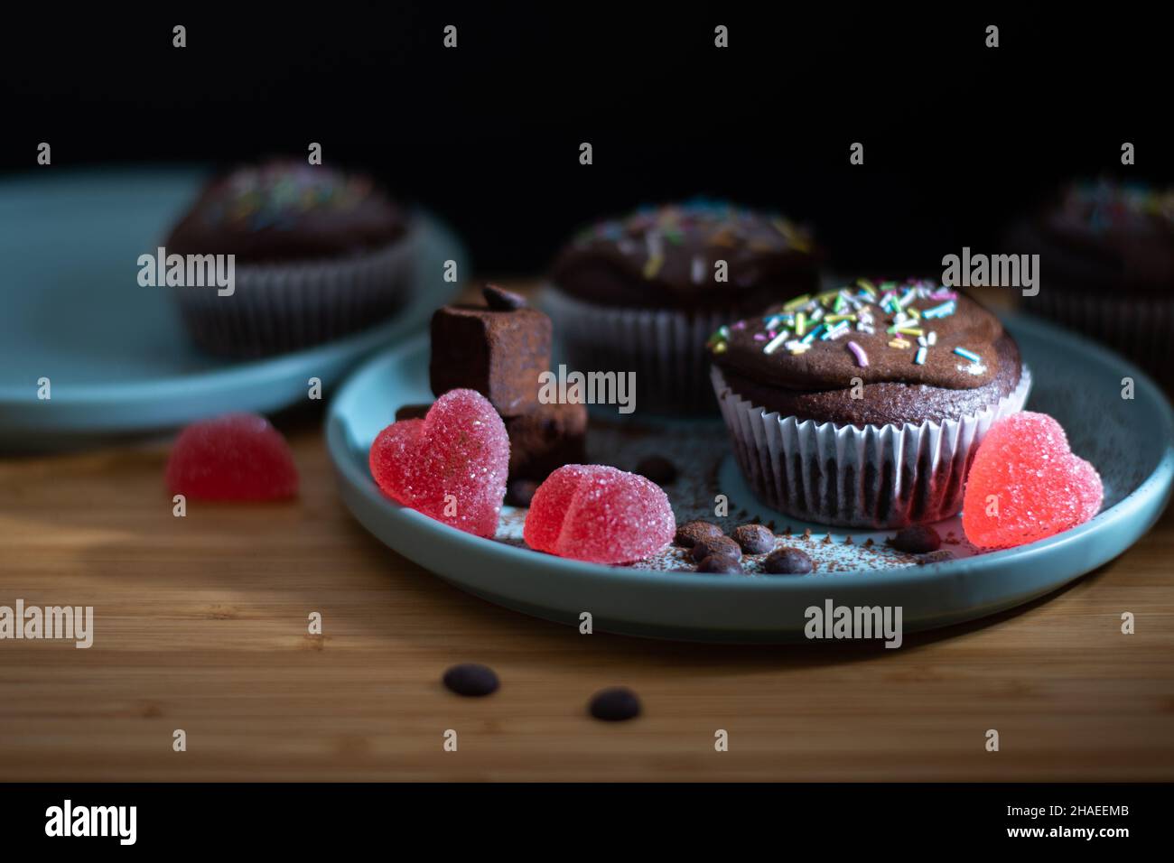 Délicieux muffin au chocolat avec topin de crème blanche aux saupoudrées colorées, truffes et bonbons en forme de coeur pour la fête de la Saint Valentin pour l'amour Banque D'Images