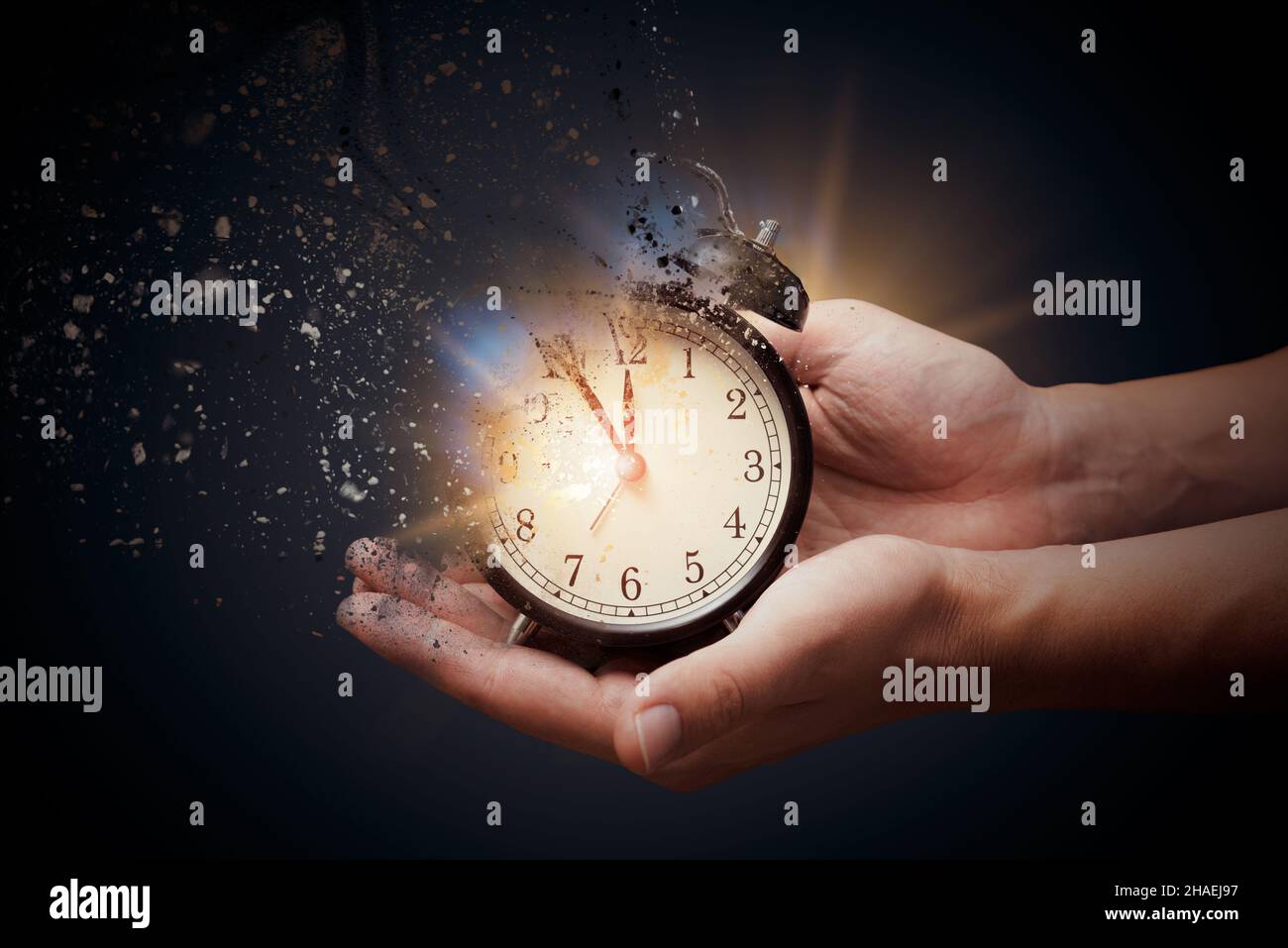 Concept de décès, l'horloge se brise en morceaux. Main tenant une horloge analogique avec effet de dispersion Banque D'Images