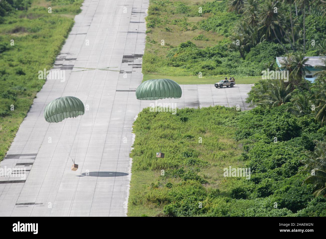 Falalop Island, États-Unis.05 décembre 2021.Les cargaisons d'air atterrissez par parachute sur l'aérodrome civil d'Ulithi après avoir été abandonnées par le US Air Force 36th Airlift Squadron pendant la chute annuelle de Noël de l'opération 70th le 5 décembre 2021 au-dessus d'Ulithi, île de Falalop, Micronésie.Chaque année en décembre, les équipages ont fait don de nourriture, de fournitures, de matériel éducatif et d'outils à 55 nations insulaires du Pacifique Sud-est.Crédit : TSgt.Joshua Edwards/US Airforce photo/Alamy Live News Banque D'Images