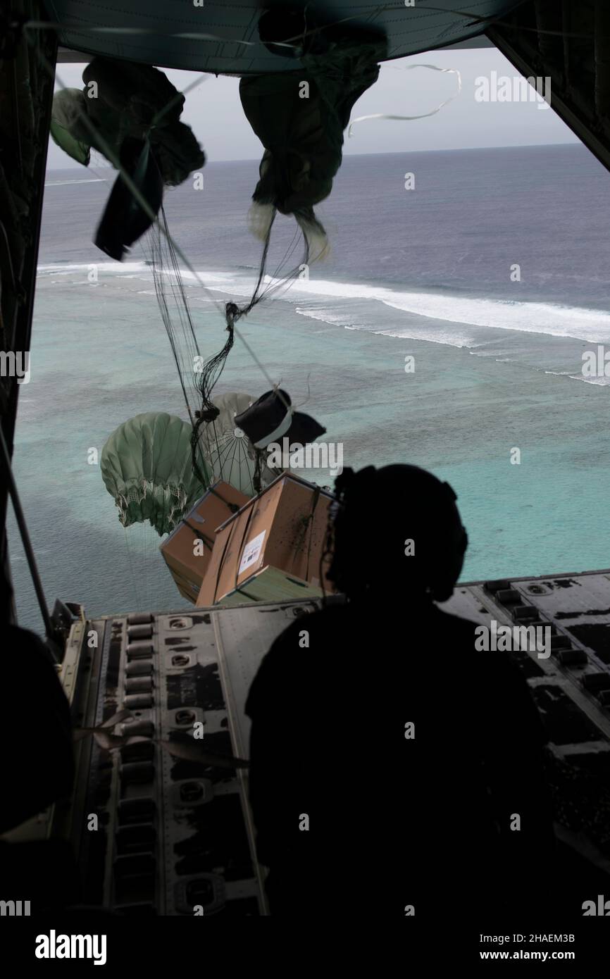 Moch Island, États-Unis.06 décembre 2021.U.S. Airman Heidi Hymel, 734th Air Mobility Squadron, regarde un paquet qu'elle a poussé d'un avion C-130J Super Hercules descendre à la terre pendant l'opération de Noël chute annuelle 70th le 6 décembre 2021 au-dessus de l'île Moch, en Micronésie.Chaque année en décembre, les équipages ont fait don de nourriture, de fournitures, de matériel éducatif et d'outils à 55 nations insulaires du Pacifique Sud-est.Crédit : TSgt.Joshua Edwards/US Airforce photo/Alamy Live News Banque D'Images