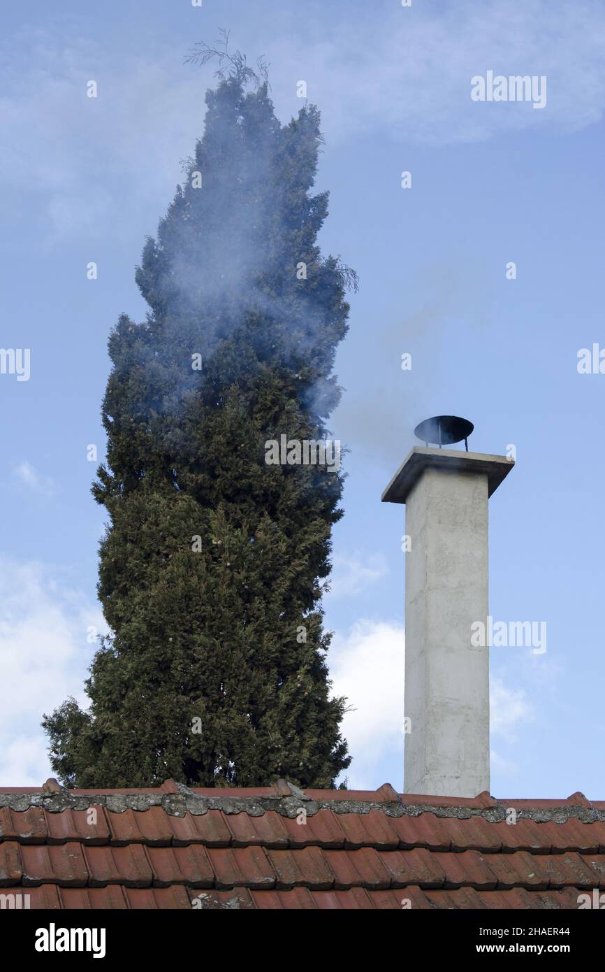 Un faible angle d'une cheminée Smokey en milieu d'hiver sur ciel bleu Banque D'Images