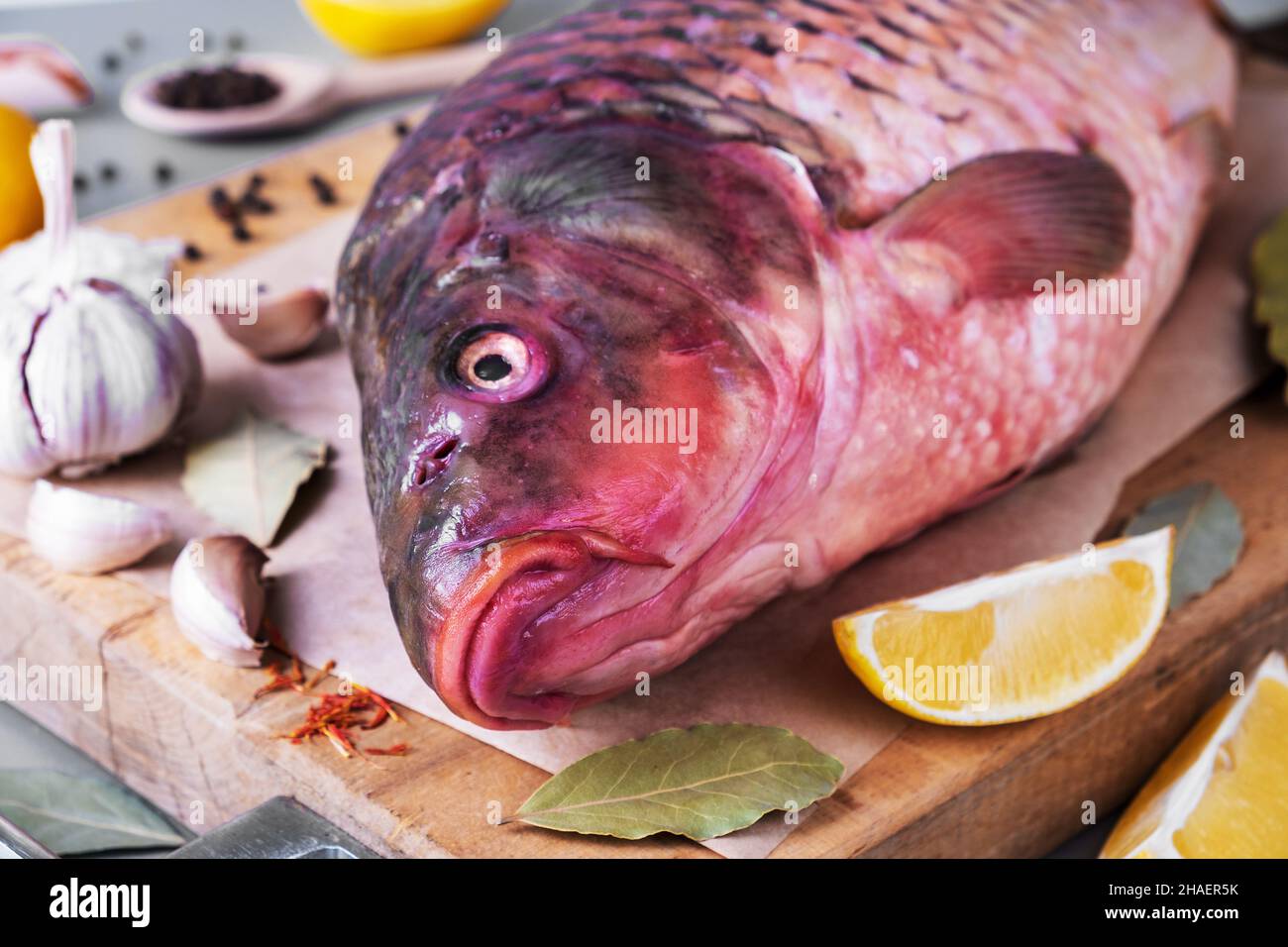 Poisson de rivière carpe sauvage sur la planche à découper avec des ingrédients pour la cuisine Banque D'Images