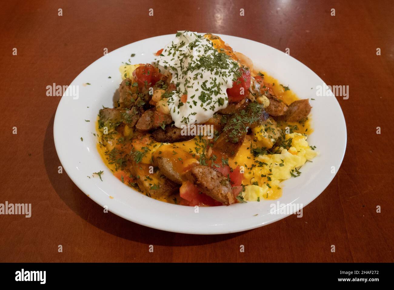 Huevos rancheros style mexicain copieux petit déjeuner œuf saucisse fromage tomate Banque D'Images