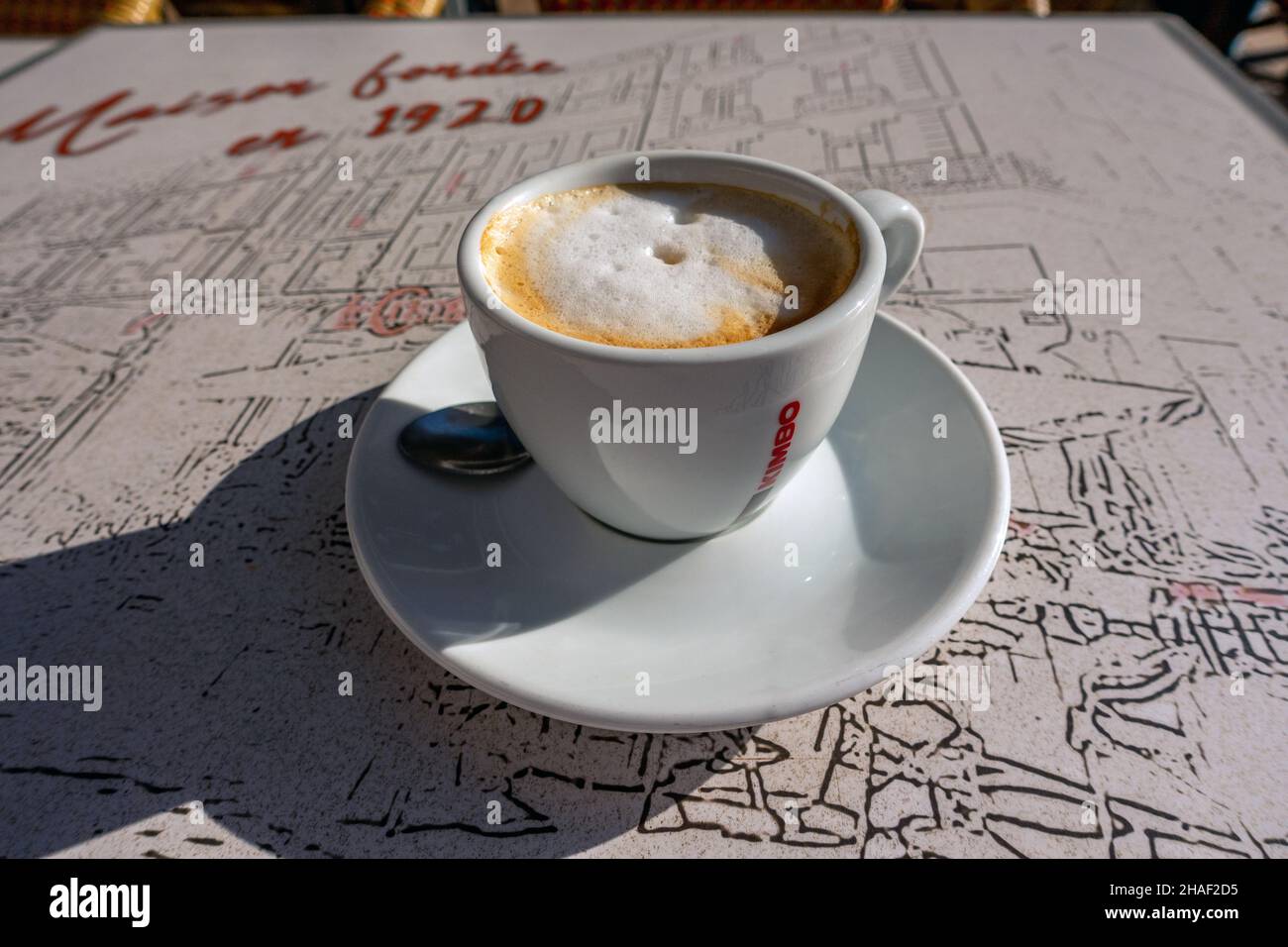 une grande tasse de cappuccino sur une table de café à la française à l'extérieur Banque D'Images