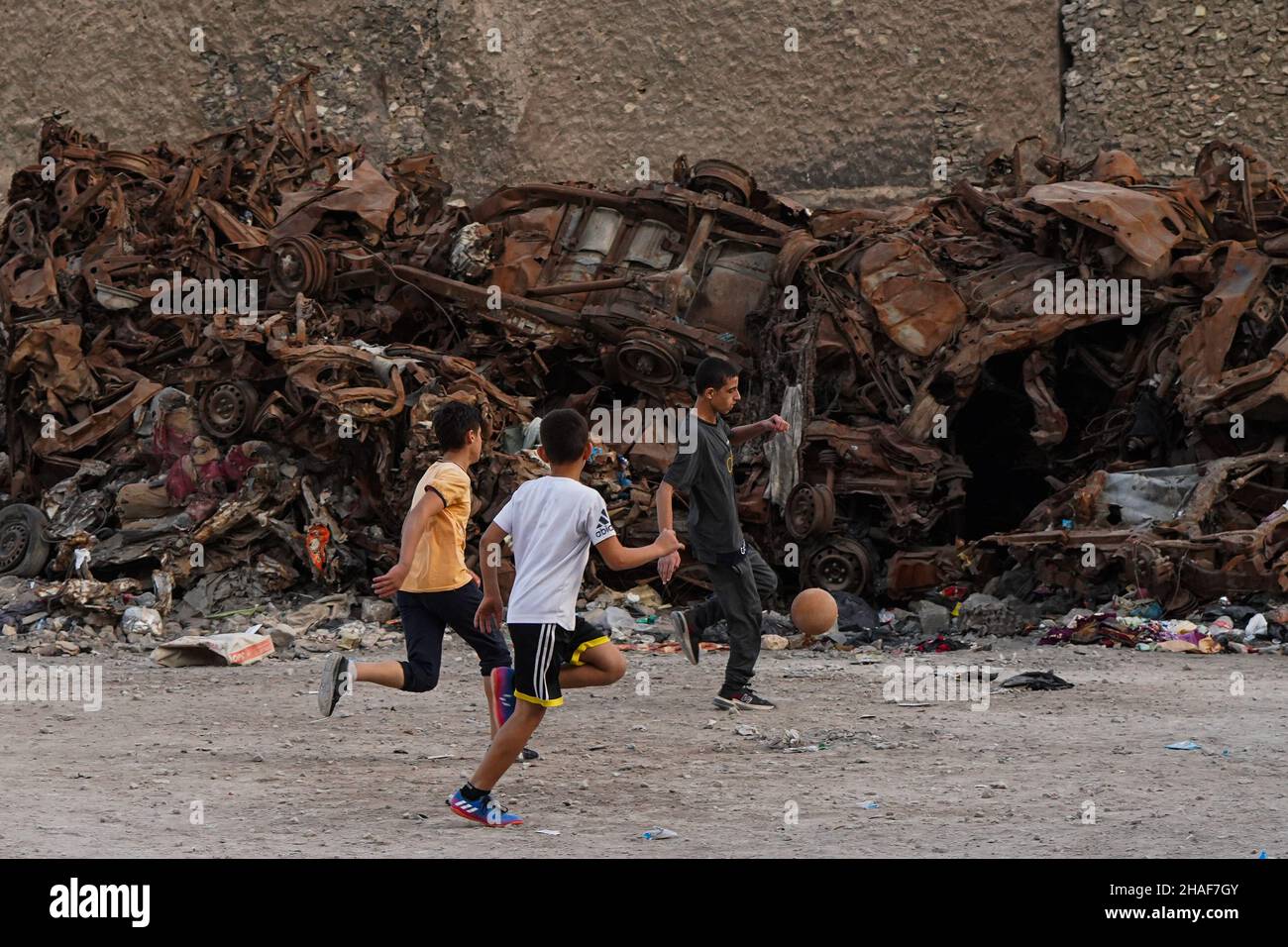 Mossoul, Irak.25th novembre 2021.Les enfants ont vu jouer au football dans une cour près de voitures brûlées à Mossoul.Crédit : SOPA Images Limited/Alamy Live News Banque D'Images