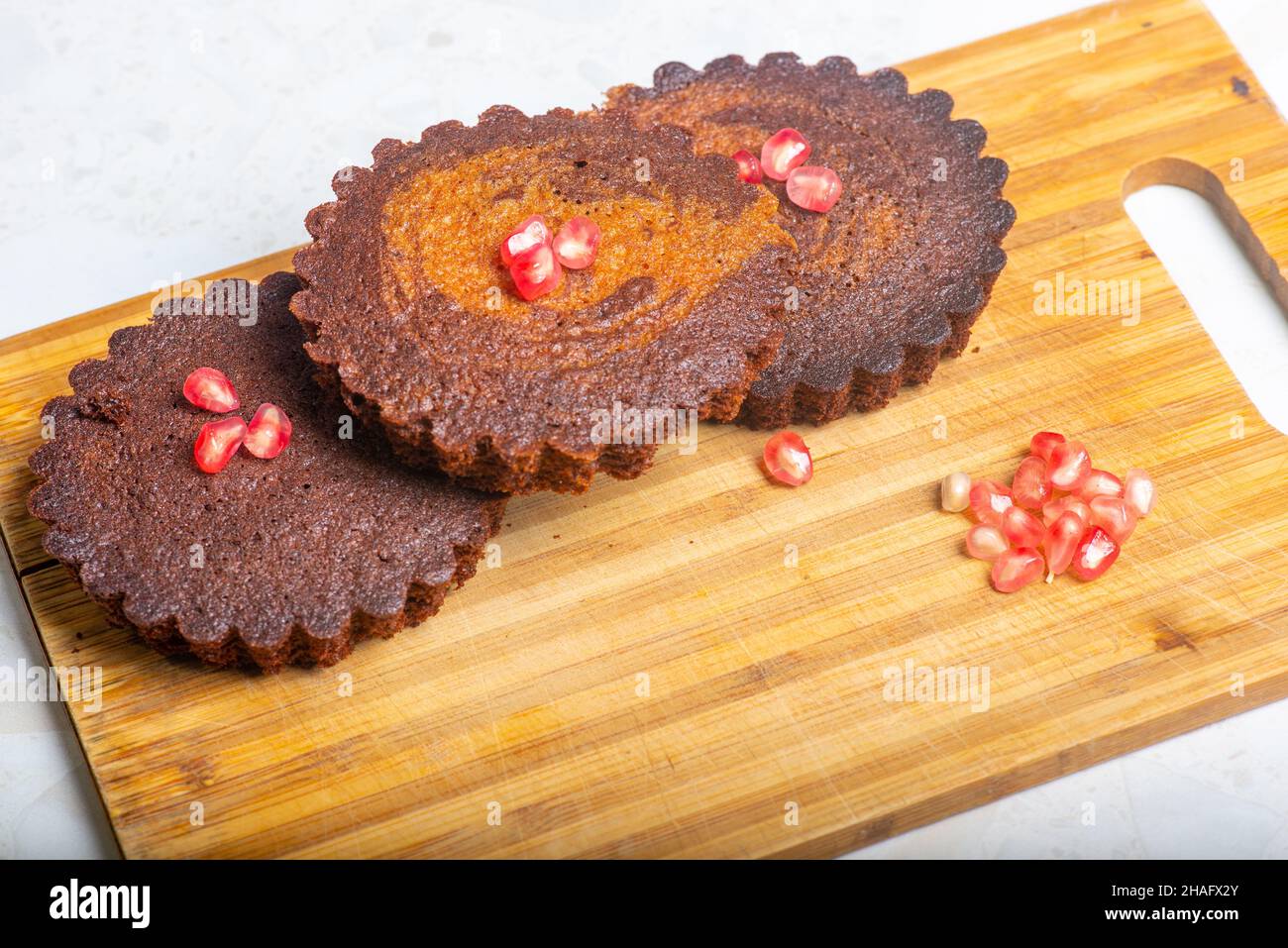 trois petites tartes de cacao avec grenade sont sur la table Banque D'Images