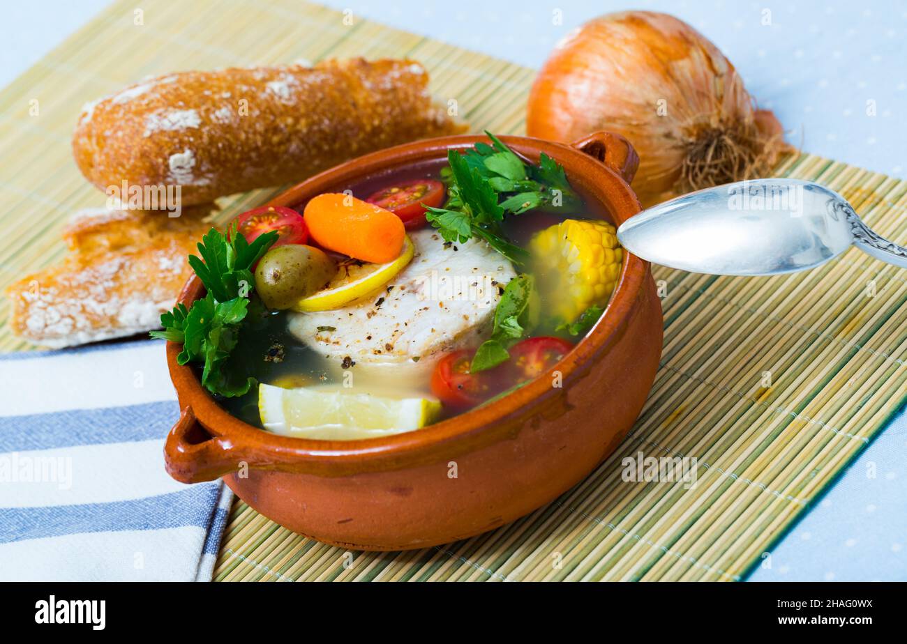 Recette potage pêcheur - bouillir merluccius tête pour bouillon. Ajouter 200 gr de steak de poisson, légumes (pommes de terre, carottes, maïs, l'échalote), sel, poivre. Faire cuire dans la vo Banque D'Images