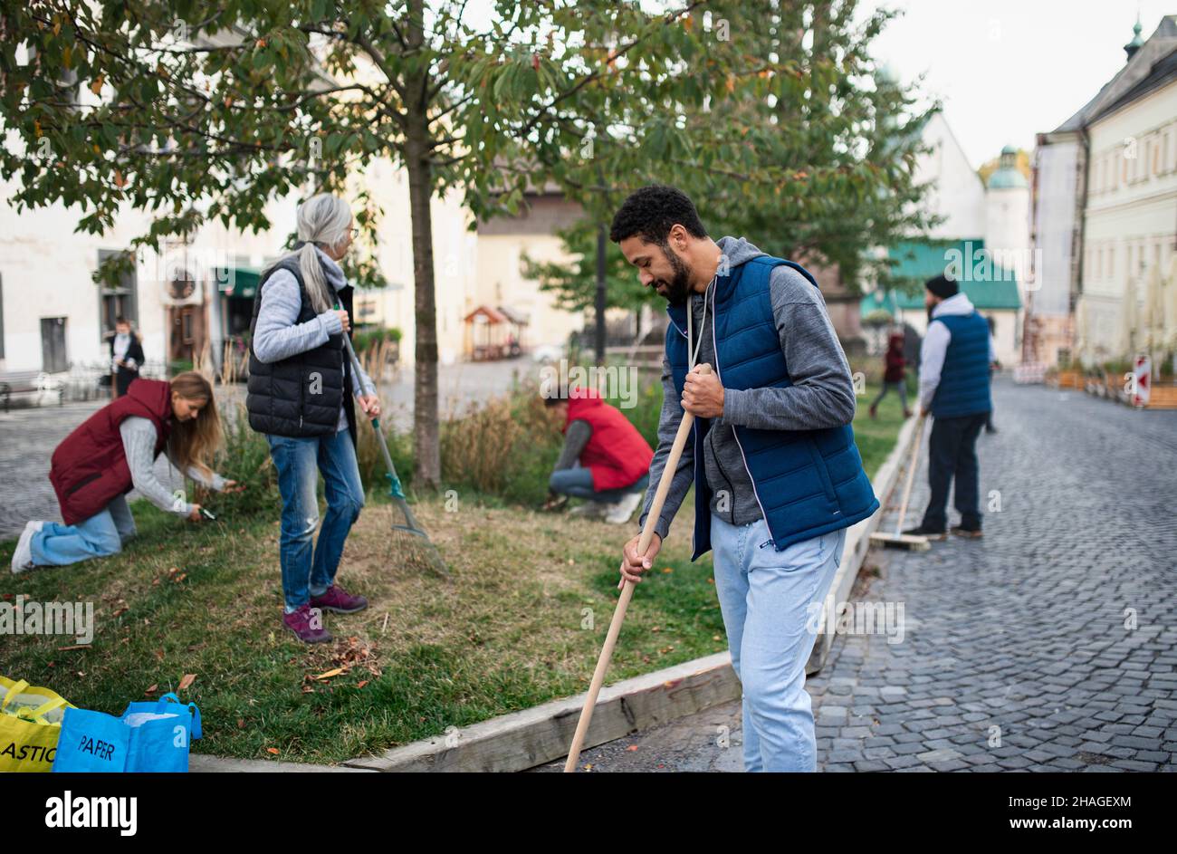 Jeune homme bénévole avec l'équipe de nettoyage de la rue, concept de service communautaire Banque D'Images