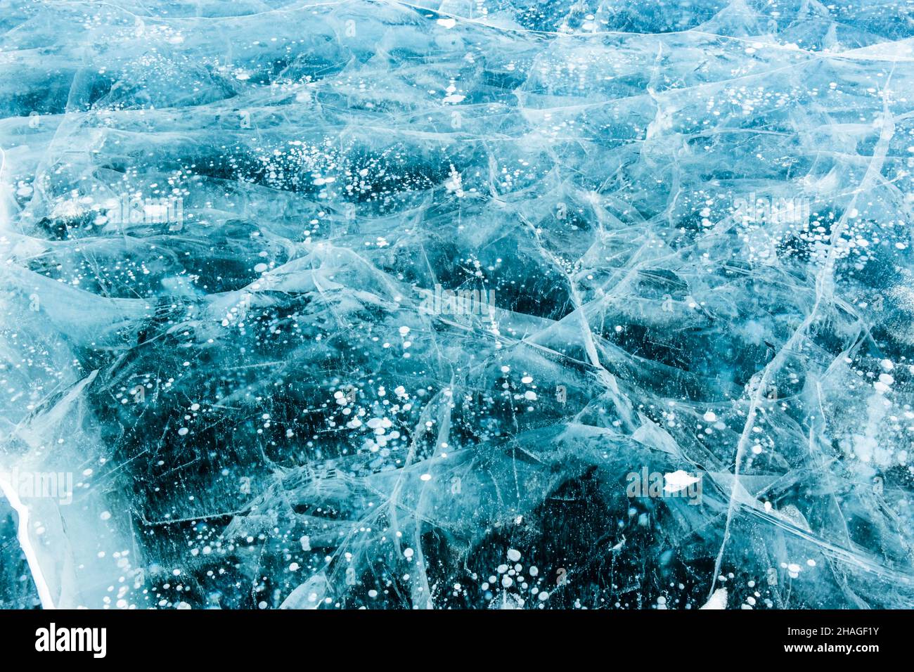 Texture de la glace bleue avec des fissures et des bulles d'air dans le lac gelé. Hiver nature fond. Banque D'Images