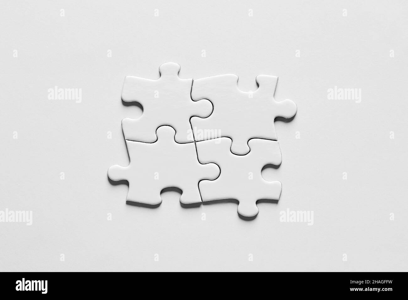 Quatre pièces de puzzle reliées les unes aux autres. Travail d'équipe, synergie, connexion, coopération, unité ou ensemble. Banque D'Images