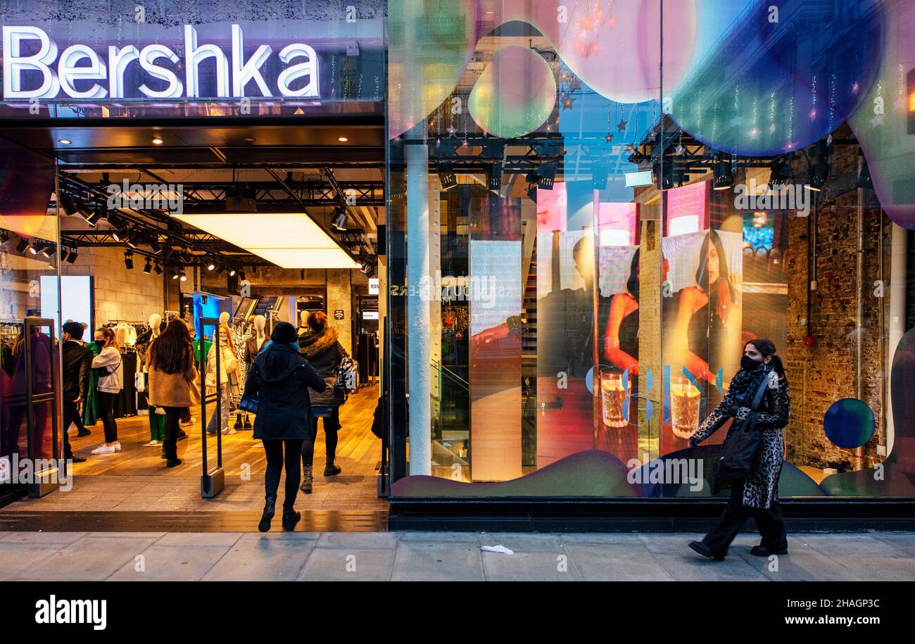 Façade de Bershka, une société de mode, à Oxford St, Londres ; scène au  crépuscule avant Noël, bondée de shoppers Photo Stock - Alamy