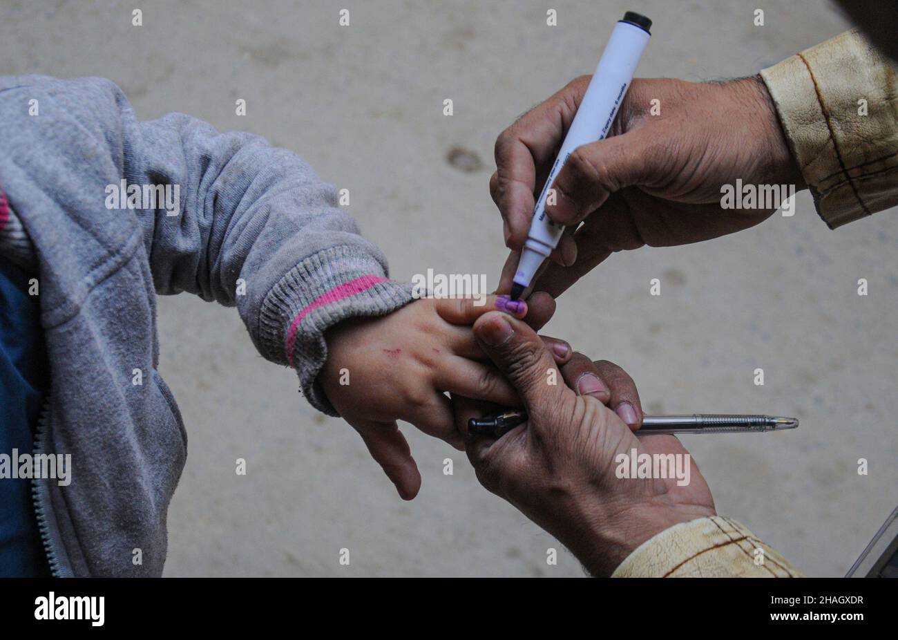 RAWALPINDI, Pakistan - décembre 13 : un agent de santé administre le vaccin contre la polio à un enfant lors d'une campagne anti-polio à Rawalpindi le 13 décembre 2021 Banque D'Images