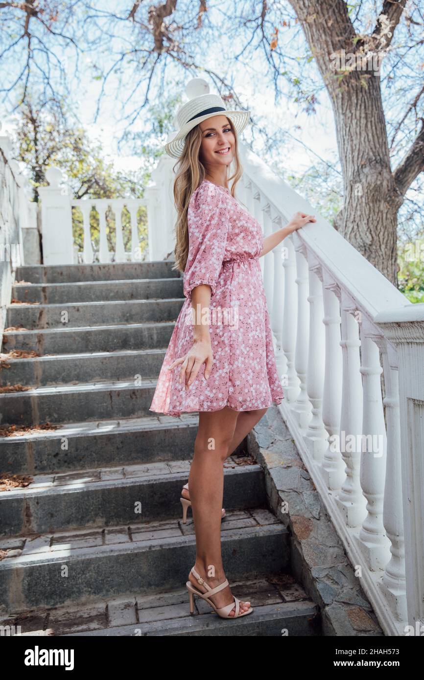 belle femme blonde dans une robe rose d'été sur une promenade autour de la  ville Photo Stock - Alamy