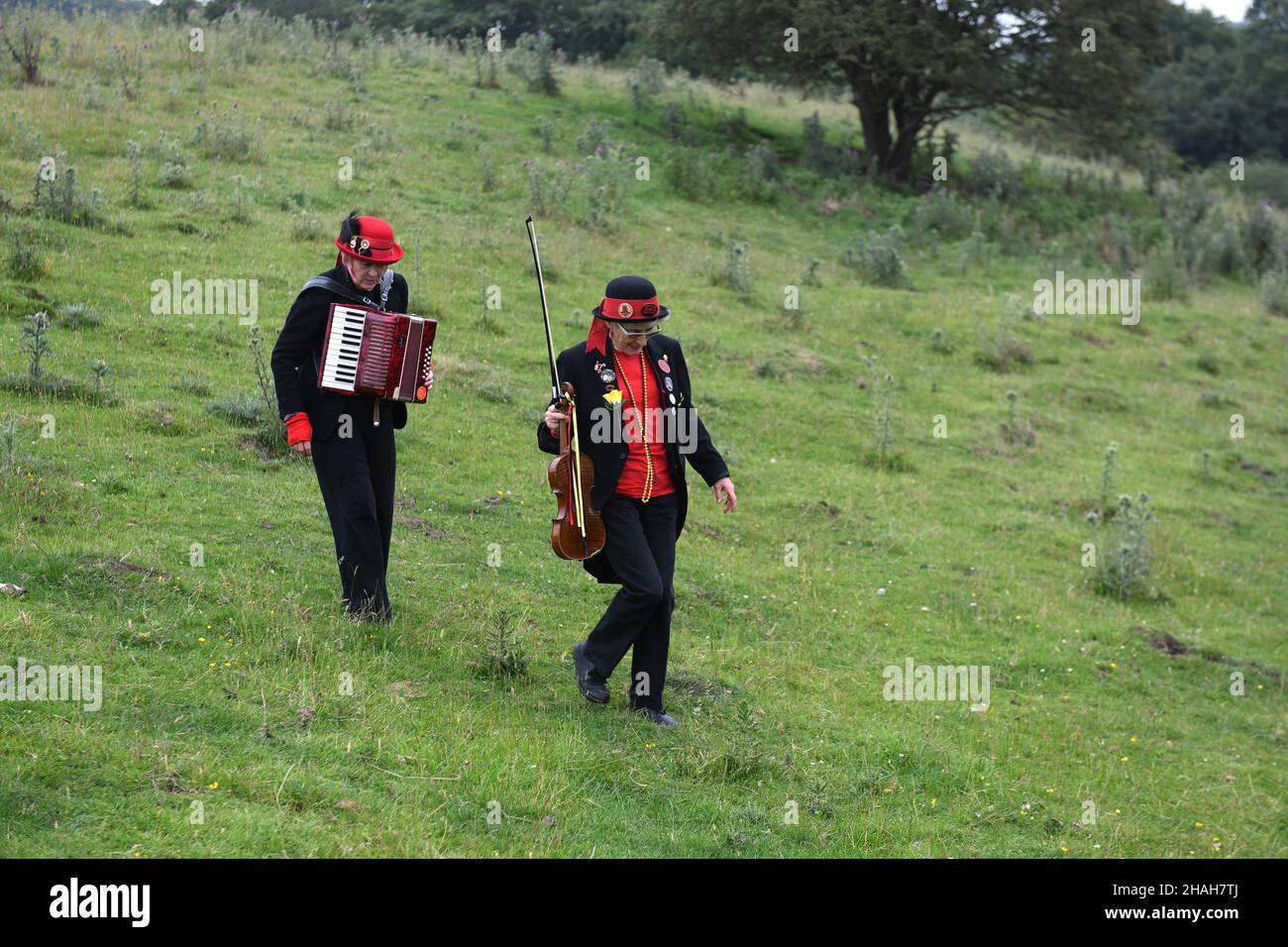 Des musiciens du groupe de danse traditionnelle Ironmen & Severn Gilders traversent un champ Banque D'Images