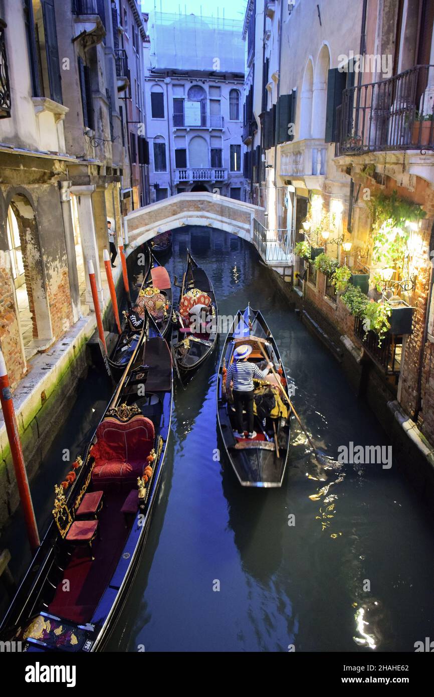 Plusieurs bateaux avec des gondoliers se reposent après le travail dans la soirée entre les bâtiments historiques sur l'eau, Venise, Italie.10.16.2019 Banque D'Images