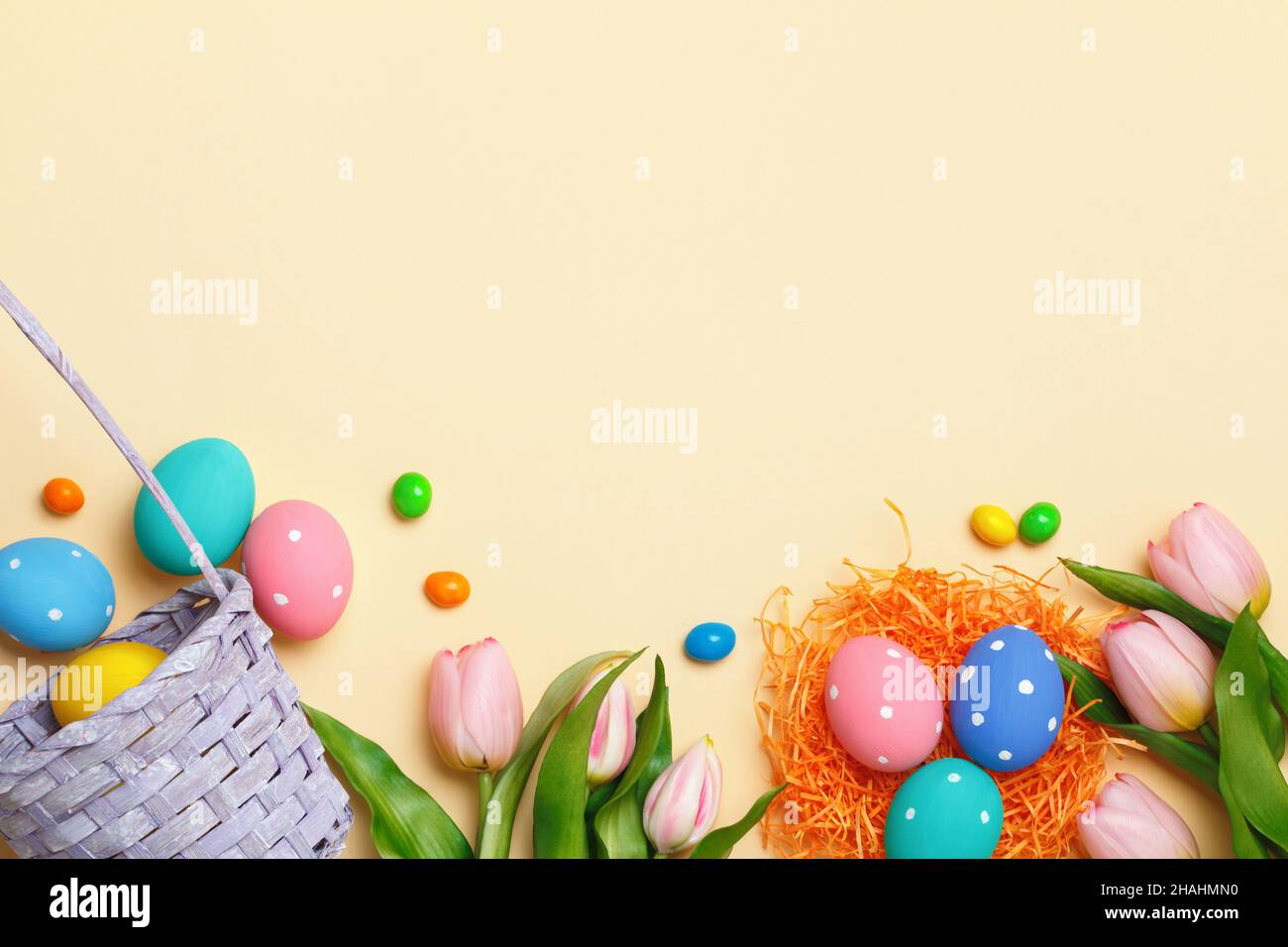 Composition de Pâques sur fond beige.Panier d'œufs de tulipes.Vue de dessus de l'espace de copie de la mise à plat Banque D'Images