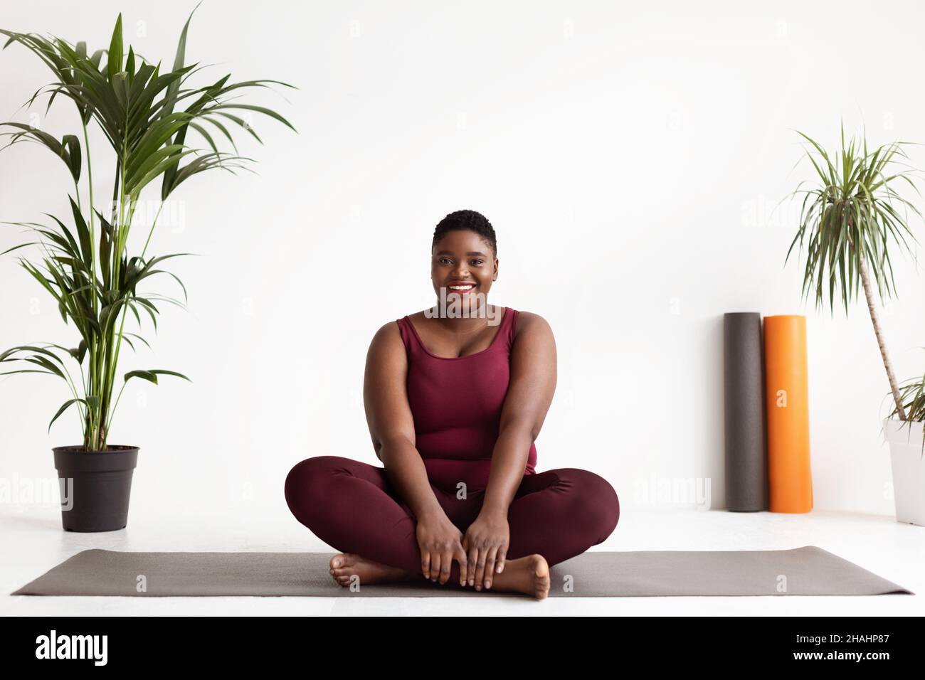 Bonne femme noire plus la taille pratiquant le yoga Banque D'Images