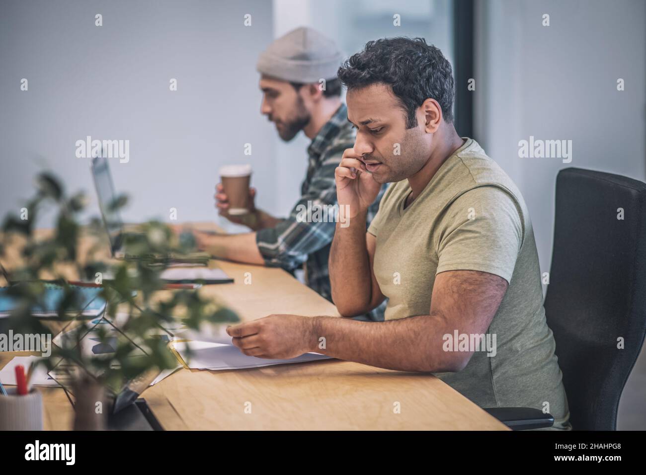 Deux personnes avec un ordinateur portable et un smartphone travaillant au bureau Banque D'Images