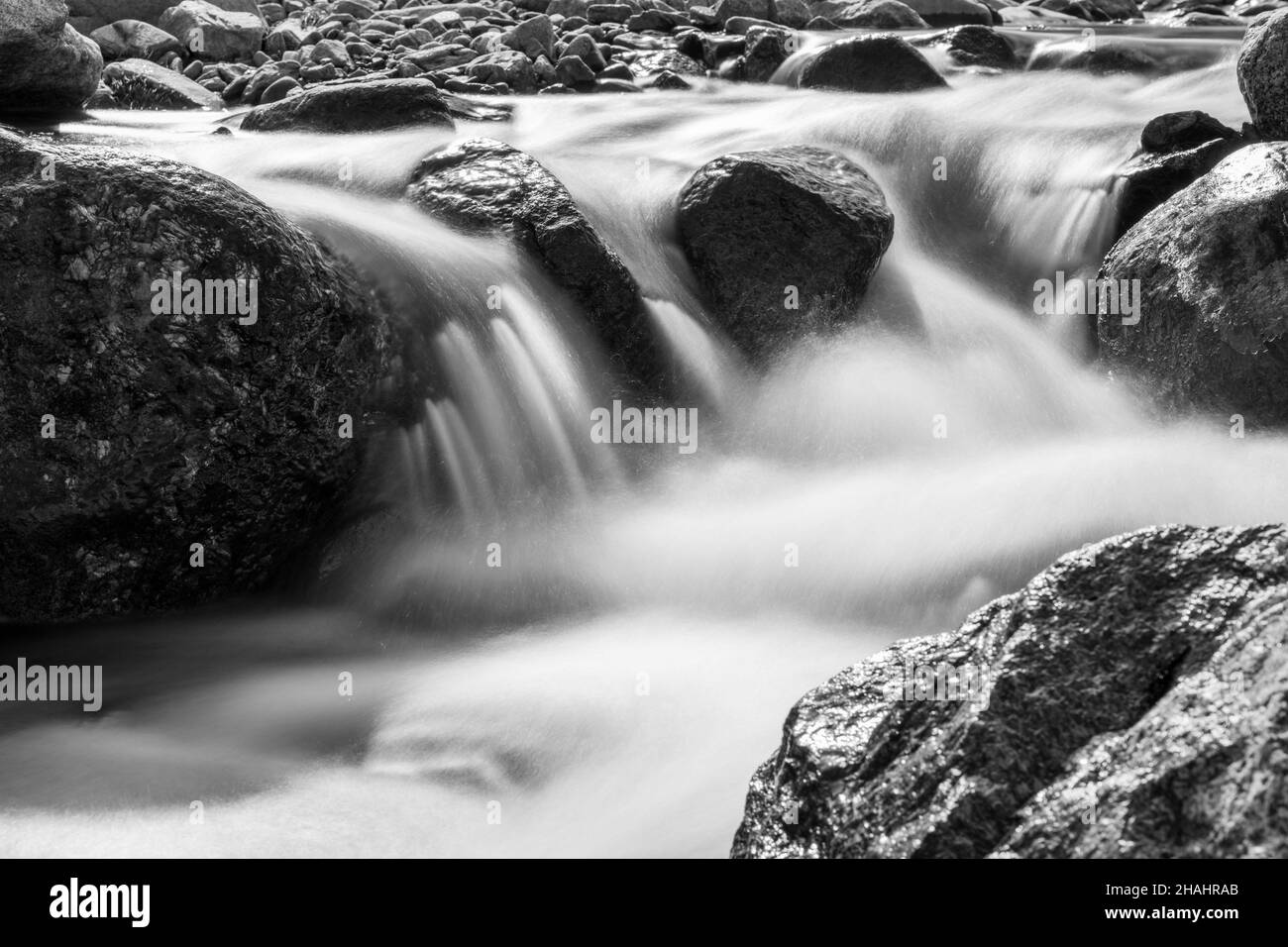 Échelle de gris de l'eau s'écoulant en aval avec une exposition longue Banque D'Images