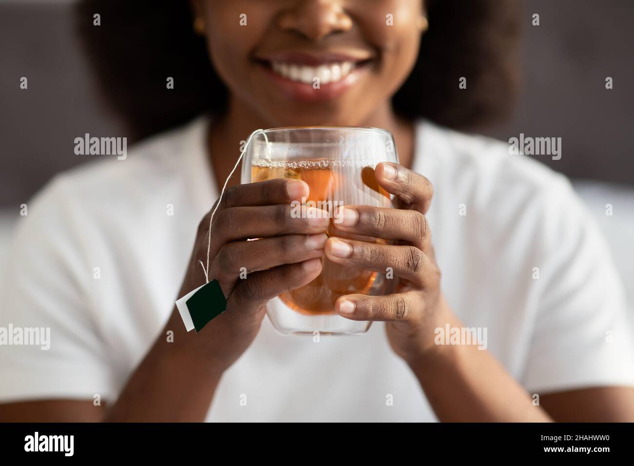 Femmes mains tenant mug avec boisson chaude, pantacourt Banque D'Images
