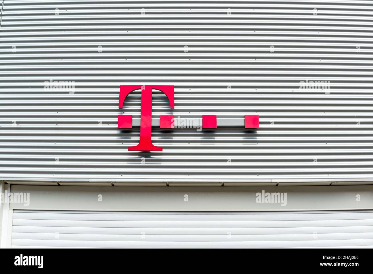 Firmenschild des Mobilfunkanbieters Telekom an einer Hausfassade vor blauem Himmel Banque D'Images