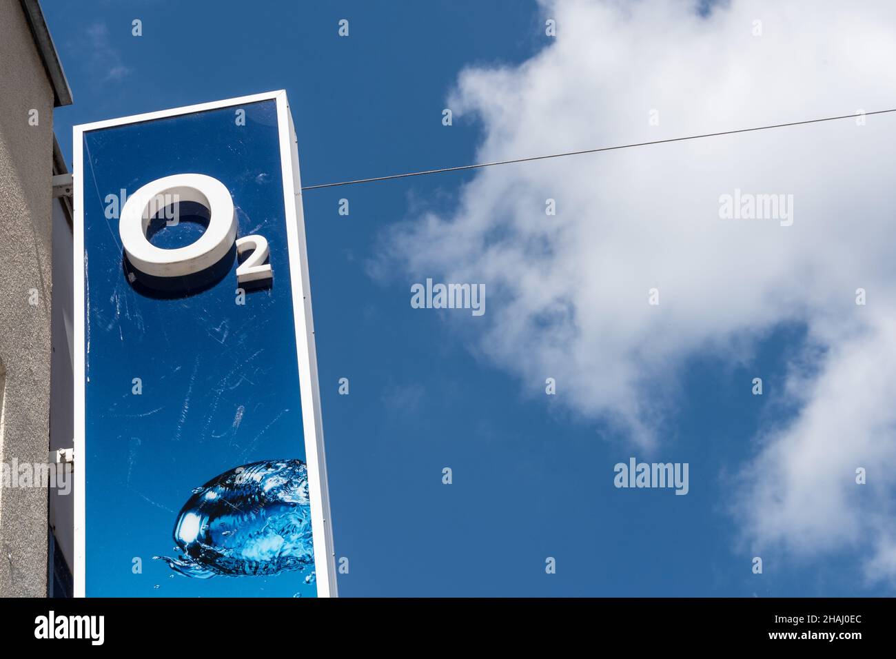Firmenschild des Mobilfunkanbieters O2 an einer Hausfassade vor blauem Himmel Banque D'Images