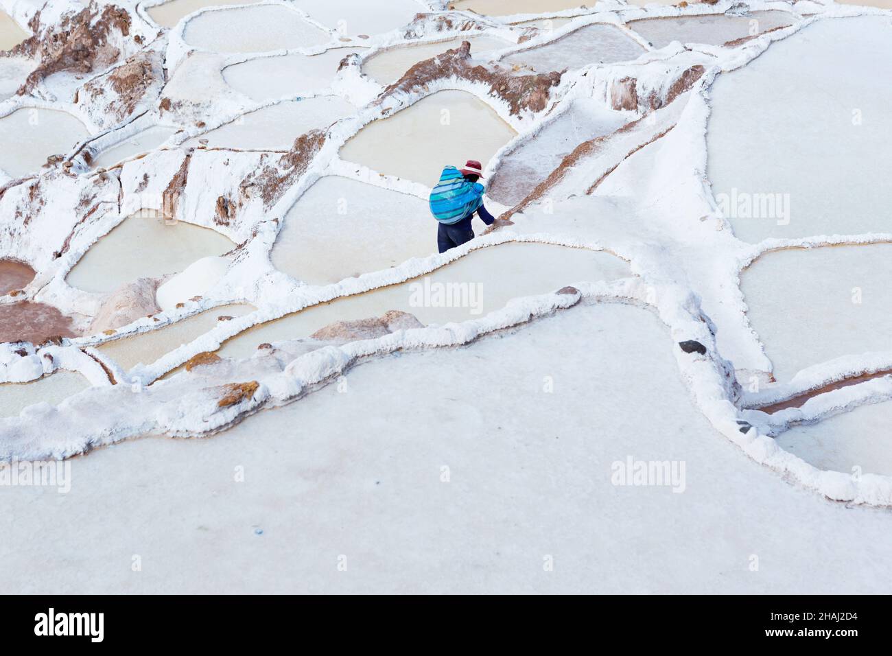 Salines à Salinas.Un ouvrier porte du sel le long des terrasses. Banque D'Images