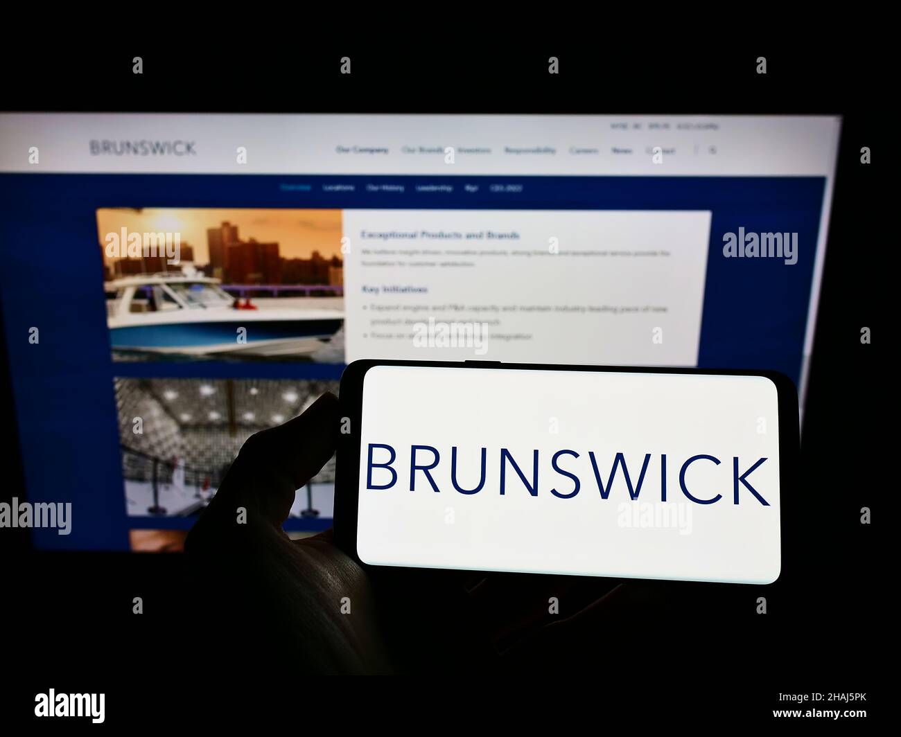 Personne tenant un smartphone avec le logo de la société américaine Brunswick Corporation à l'écran devant le site Web.Mise au point sur l'affichage du téléphone. Banque D'Images