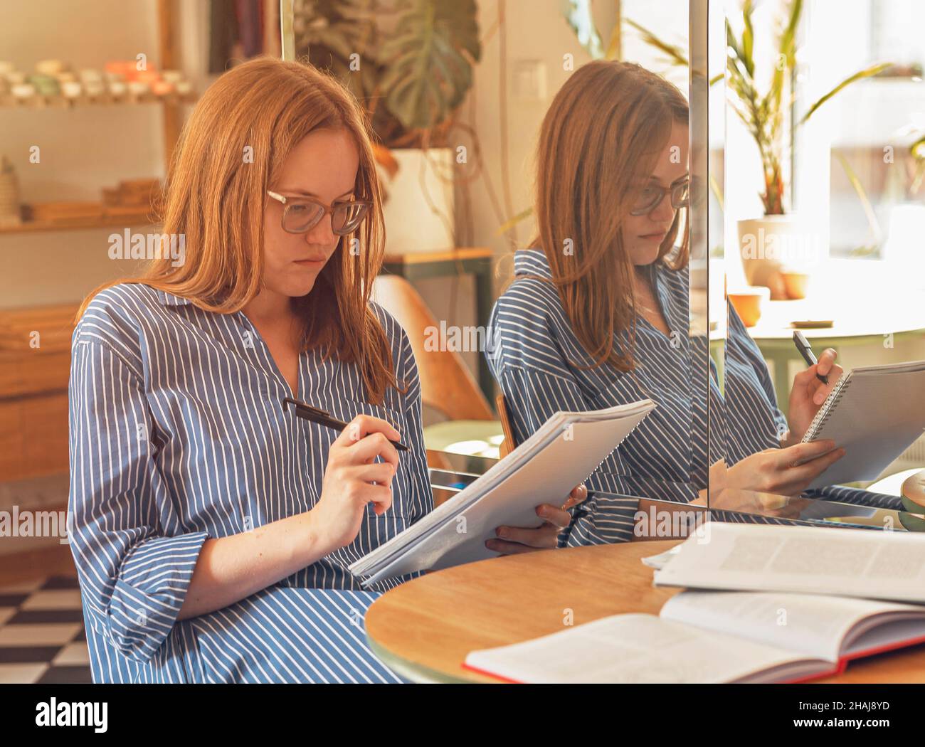 Je pense pensive femme intelligente dans un café avec stylo et ordinateur portable. Banque D'Images