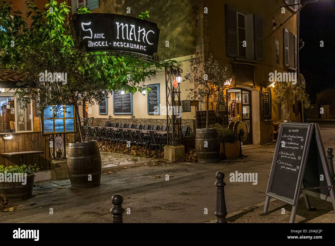 L’hôtel-restaurant Saint Marc à Aups, dans le département du Var, en France, accueille ses clients le soir sous son enseigne éclairée ; le chef Alexandre Dimitch dirige la cuisine et l’établissement. Banque D'Images