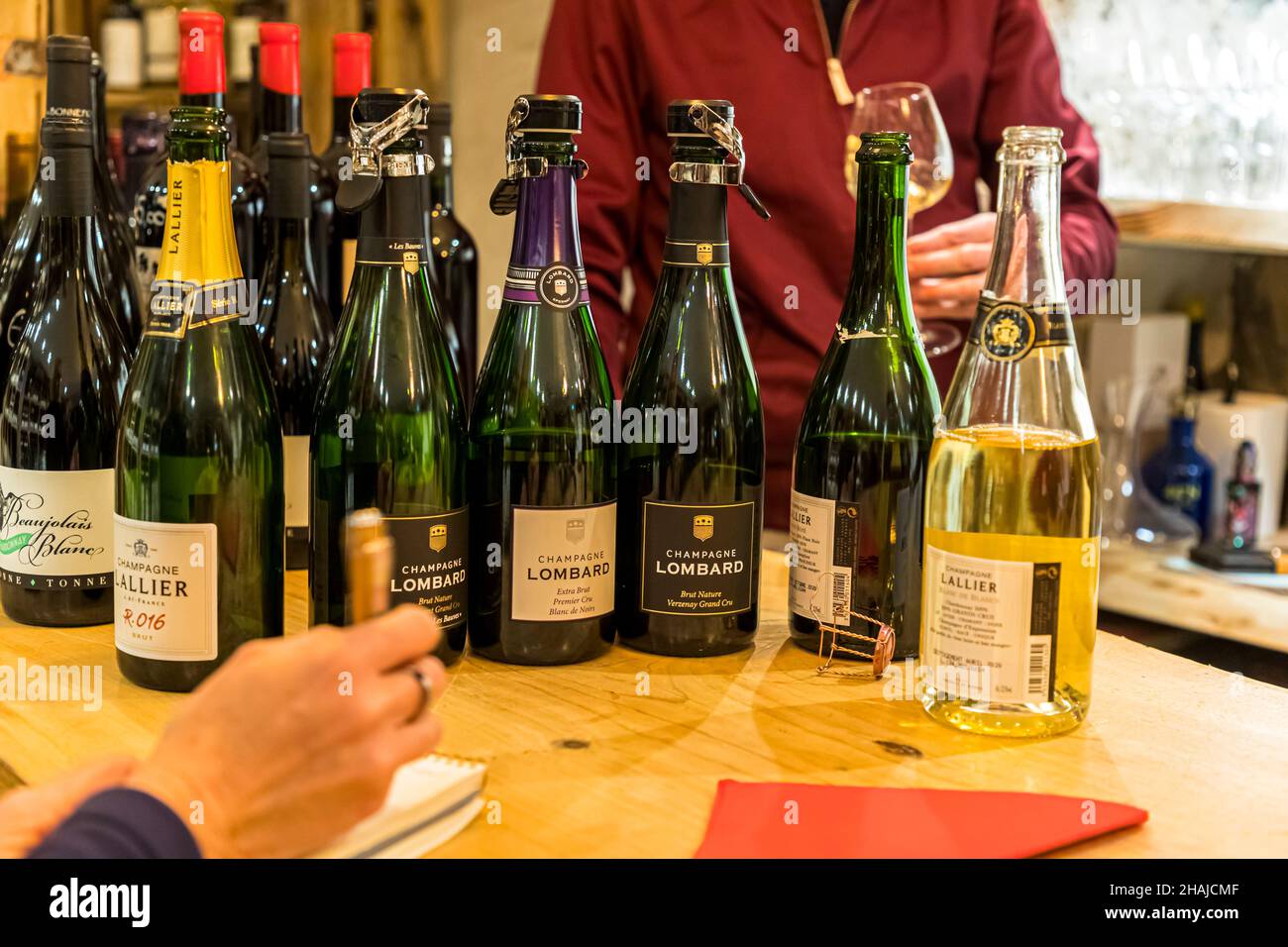 Des bouteilles de Beaujolais Blanc accompagnées de plusieurs cuvées de champagne des maisons Lallier et Lombard, alignées lors d'une dégustation dans la cave du restaurant Saint Marc à Aups, dans le Var, en France. Banque D'Images