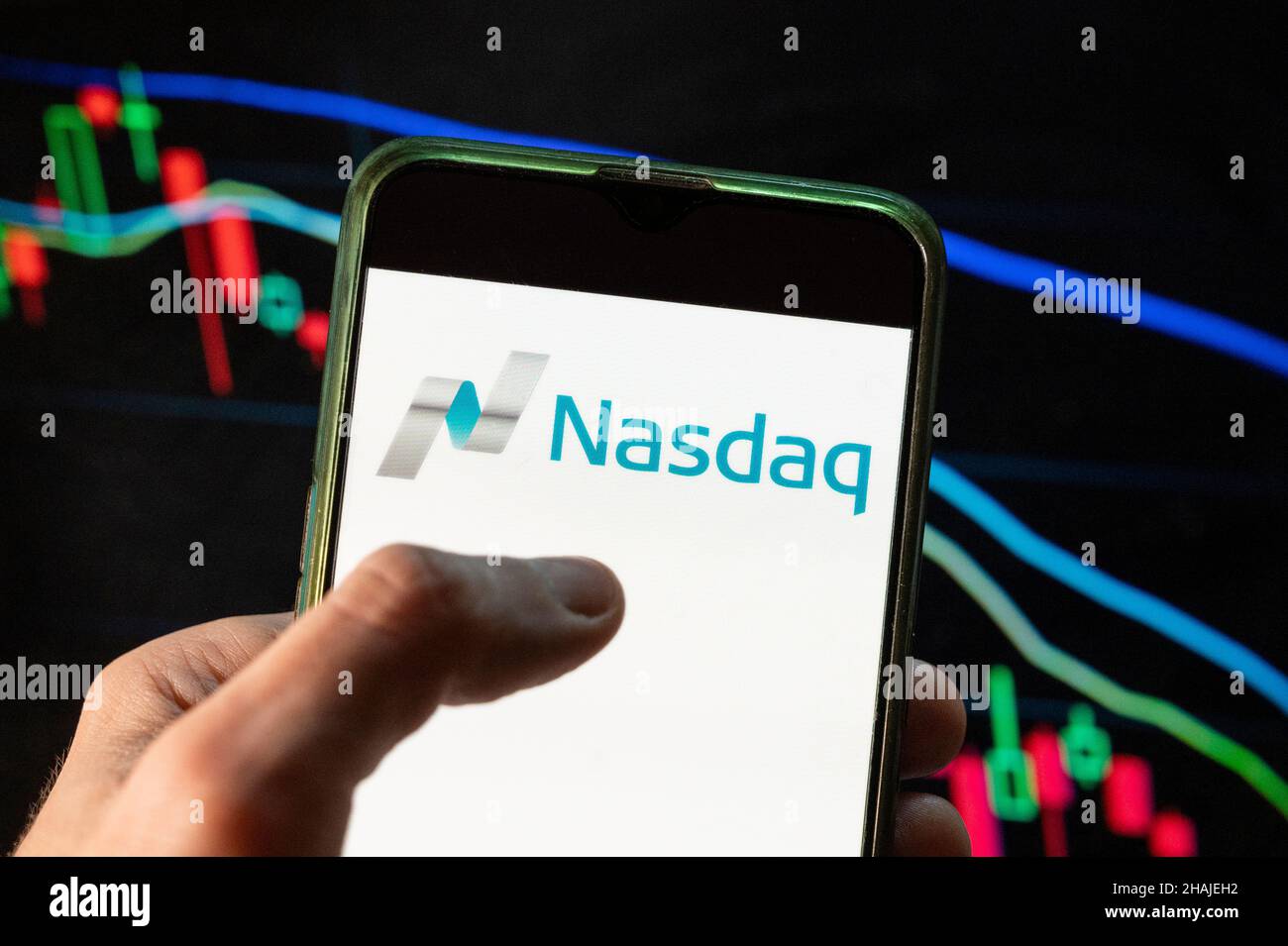 Dans cette illustration, l'indice boursier américain, le logo Nasdaq vu affiché sur un smartphone avec un graphique de l'indice boursier économique en arrière-plan. Banque D'Images