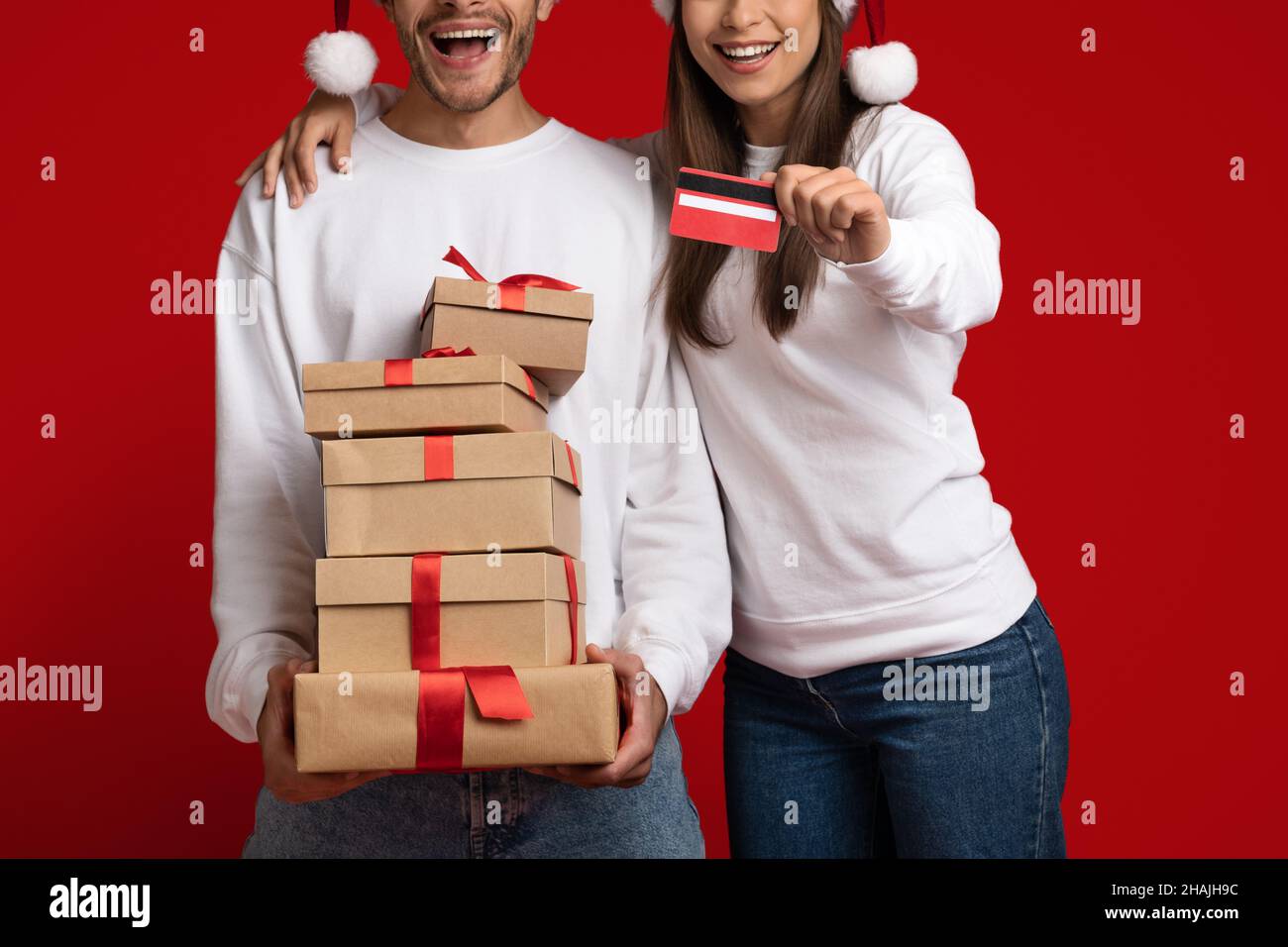 Achats de vacances.Couple joyeux avec carte de crédit et pile de cadeaux, court Banque D'Images