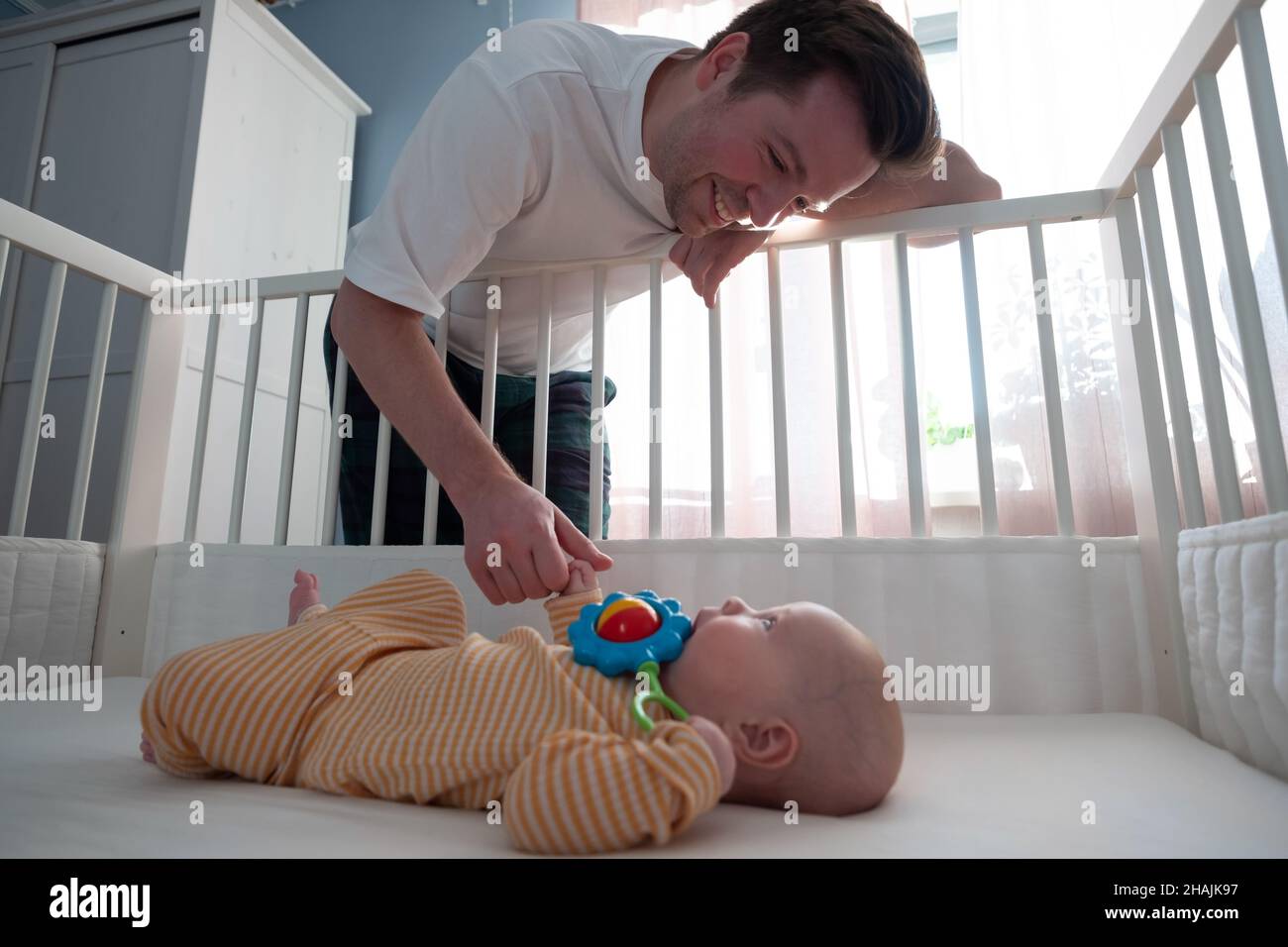 Un parent jouant avec un sac à bandoulière weth son enfant Banque D'Images