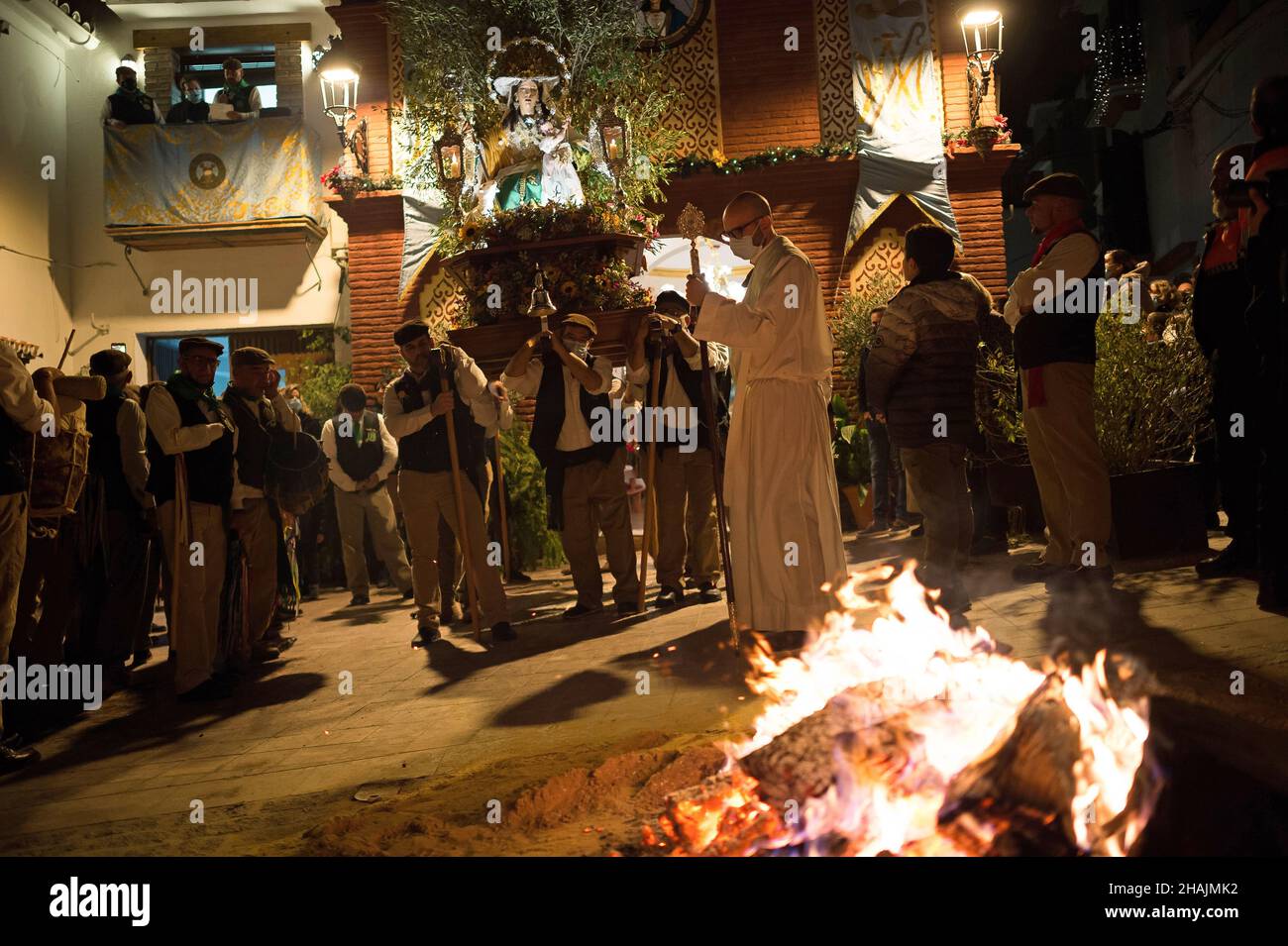 Un prêtre est vu bénir un feu de joie lors de la célébration de la procession de la Vierge de 'Divina Pastora'.À la veille de la fête de Sainte-Lucie dans le petit village de Casarabonela, chaque nuit du 12 décembre pendant la saison de Noël, les villageois prennent part à la célébration antique de 'Los Rondeles' portant des paniers de wckers en feu (également connu sous le nom de 'rondeles') trempés dans l'huile.Le long des rues, la Vierge de 'Los Rondeles' est honorée par les dévotés dans un rituel de lumière et de feu comme action de grâce pour la récolte obtenue.(Photo de Jesus Merida/SOPA Images/Sipa USA) Banque D'Images