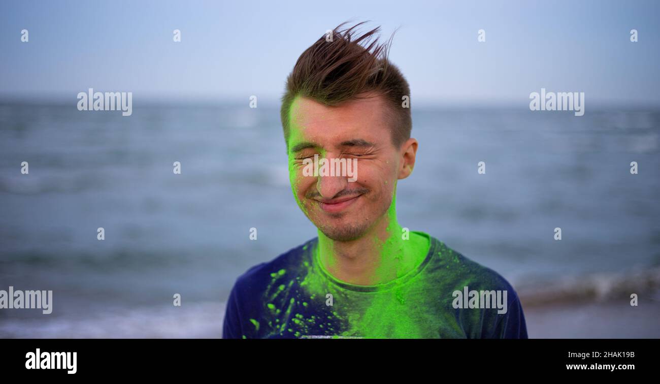 Un jeune homme jette de la poudre de couleur sur le fond de la mer Banque D'Images