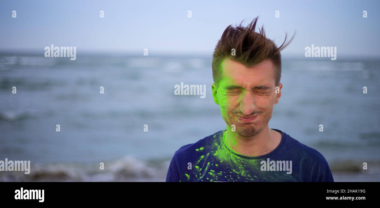 Un jeune homme jette de la poudre de couleur sur le fond de la mer Banque D'Images
