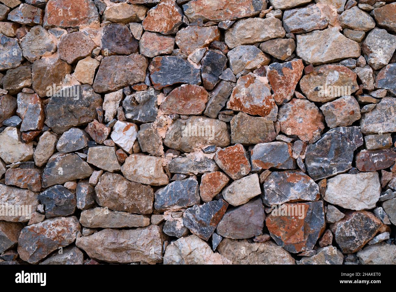 Fond texturé de mur de maçonnerie en pierres multicolores naturelles. Banque D'Images