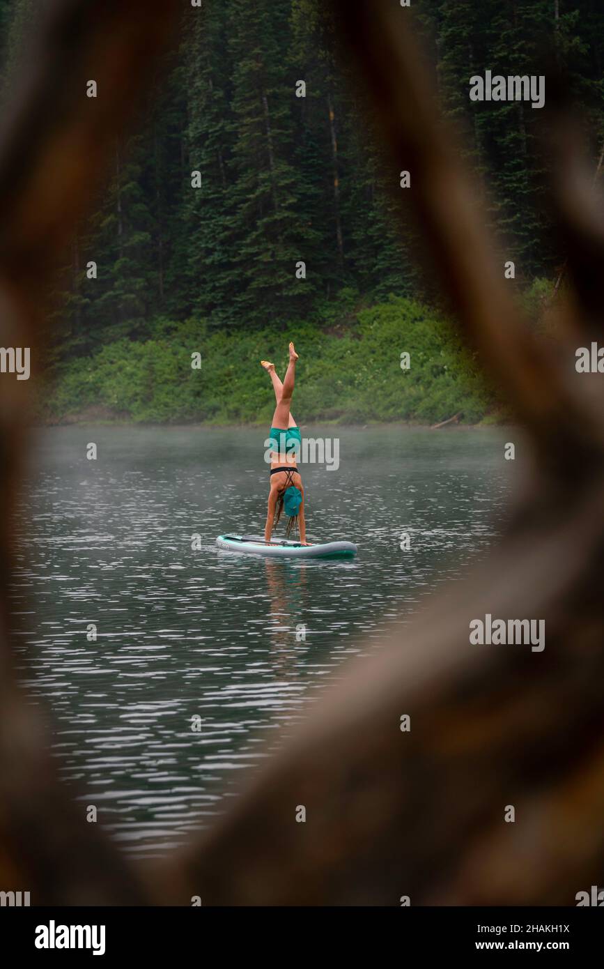 7/14/21 - Crested Butte, Colorado - Une femme montre comment faire des stands et du yoga sur un paddle board. Banque D'Images