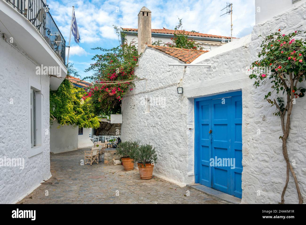 Une rue pittoresque de maisons blanchies à la chaux et un café-terrasse dans le village de la petite île grecque d'Hydra, en Grèce. Banque D'Images