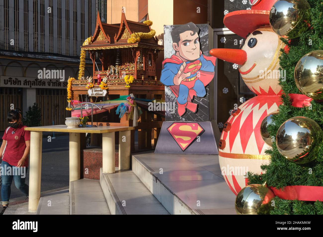 Mélange culturel : décoration de Noël au Mega Plaza de Bangkok, en Thaïlande, avec un sanctuaire d'esprit (l), une représentation de Superman, un bonhomme de neige et un arbre de Noël Banque D'Images