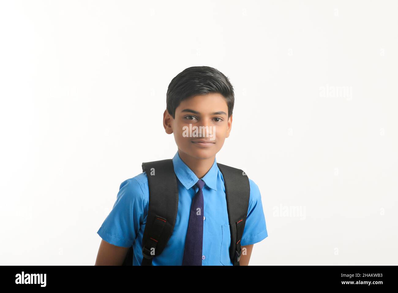 Garçon d'école indienne debout sur fond blanc. Banque D'Images