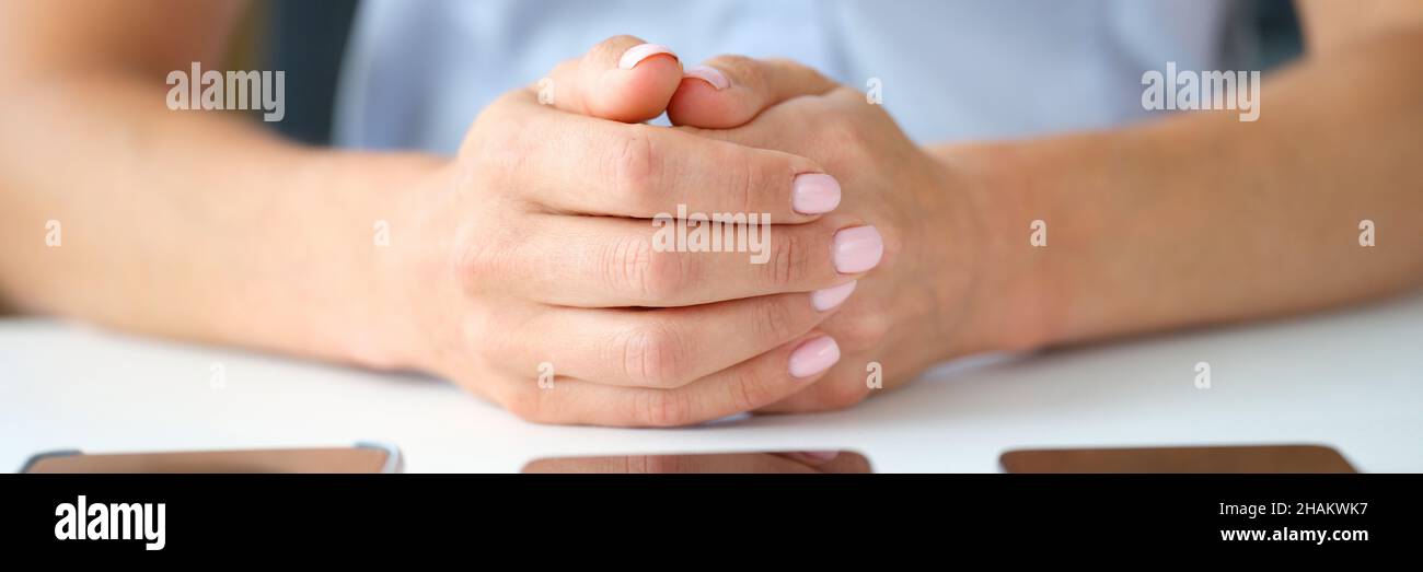 Une femme d'affaires choisit un smartphone allongé sur une table de près Banque D'Images