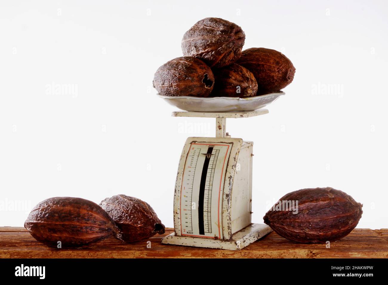 fèves de cacao sur de vieilles balances métalliques sur des poutres en bois, isolées Banque D'Images