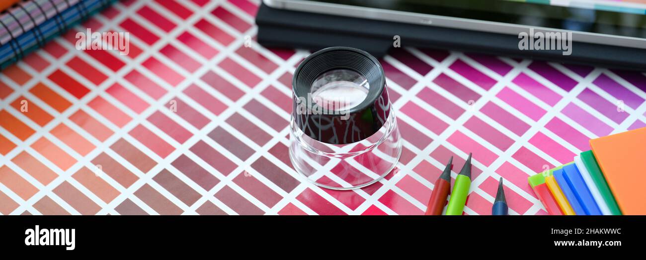 Petite loupe au-dessus de la palette de couleurs et des échantillons avec différentes nuances de couleurs Banque D'Images